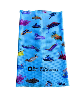 Buff multifuncional The Ocean Lung con estampado de nudibranquios de colores sobre fondo rosa-lila, línea Ocean Ambassadors. Alt text (imagen de detalle/doblado): Detalle de la costura y logo de The Ocean Lung en el buff Nudibranquios Rosa, tela mesh técnica rosa-lila.